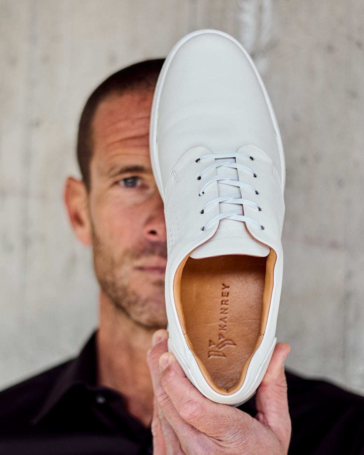 Front view of white RONIN in front of model’s face. KANREY derby shoes in white.