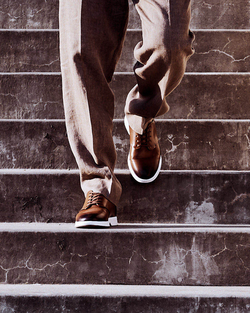 RONIN in tan on stairs – model not visible. KANREY derby shoes in tan.